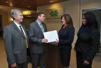 Marshall University School of Pharmacy receives diversity grant from Walgreens Dr. H. Glenn Anderson, associate dean of academic and curricular affairs, accepts a diversity grant packet from Dr. Debra Harris, pharmacy supervisor, Walgreens.